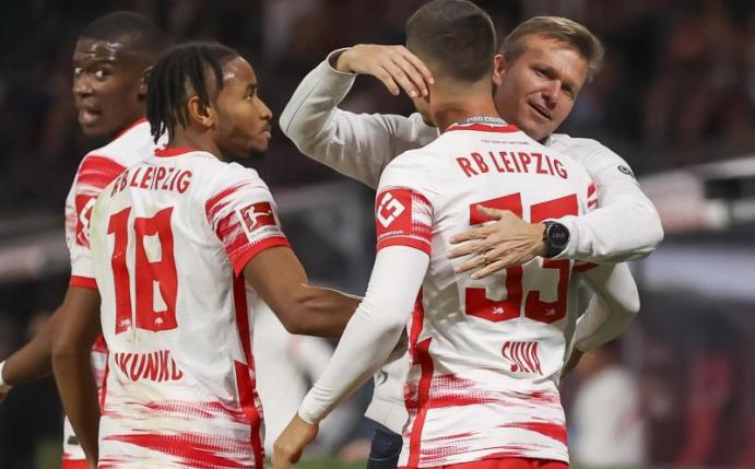 Leipzigs Christopher Nkunku (l), Trainer Jesse Marsch (r) und Torschütze Andre Silva freuen sich über die 1:0-Führung gegen den VfL Bochum. Foto: Jan Woitas/dpa-Zentralbild/dpa