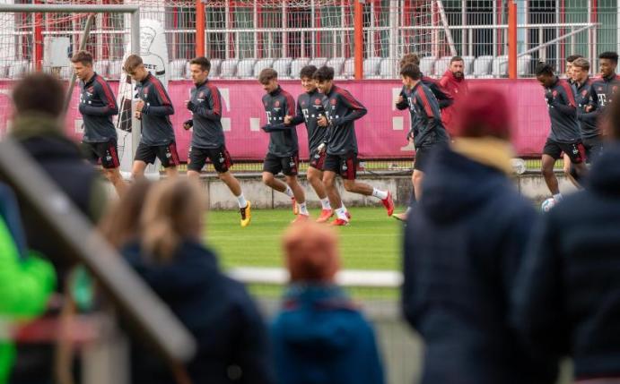 Nach langer Zeit wieder ein öffentliches Training: Spieler und Trainer des FC Bayern München laufen sich vor anwesenden Fans warm. Foto: Peter Kneffel/dpa