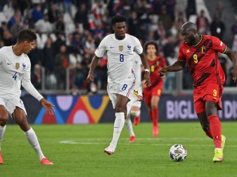 Frankreichs Aurelien Tchouameni (M) und Belgiens Romelu Lukaku (r) kämpfen um den Ball. Foto: Dirk Waem/BELGA/dpa
