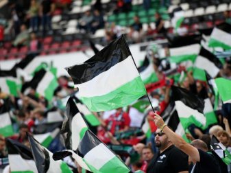 Hannover 96 hofft auf ein wieder voll ausgelastetes Stadion: Fans schwenken Fahnen. Foto: Daniel Reinhardt/dpa