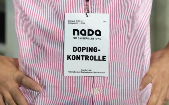 Ein Mitarbeiter der Nationalen Anti Doping Agentur (NADA) trägt einen Ausweis mit der Aufschrift "Dopingkontrolle" um den Hals. Foto: Sebastian Kahnert/dpa/Archivbild