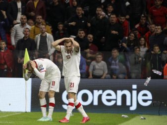 Polen Spieler schützen sich vor den Flaschenwürfen der albanischen Anhänger. Foto: Franc Zhurda/AP/dpa