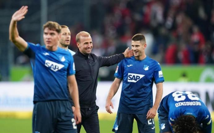 Hoffenheims Robert Skov, Trainer Sebastian Hoeneß, Benjamin Hübner und Georginio Rutter (l-r) feiern nach der Partie. Foto: Uwe Anspach/dpa