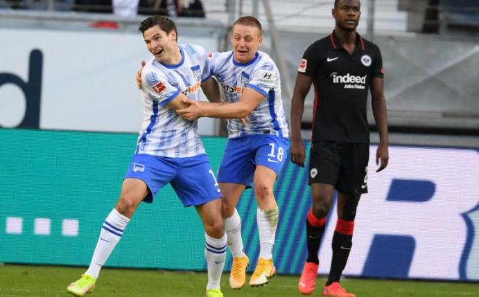 Herthas Torschütze Jürgen Ekkelenkamp (l-r) und Santiago Ascacibar jubeln nach dem Tor zum 2:0 neben Frankfurts Evan Ndicka. Foto: Arne Dedert/dpa