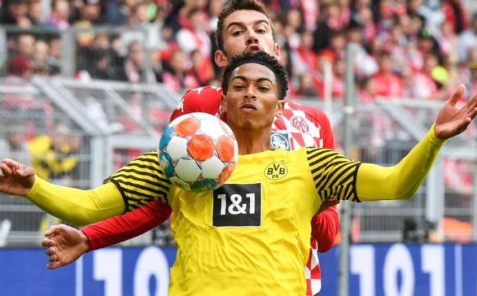 Dortmunds Mittelfeldspieler Jude Bellingham schirmt den Ball geschickt mit dem eigenen Körper vor dem Mainzer Stefan Bell ab. Foto: Bernd Thissen/dpa