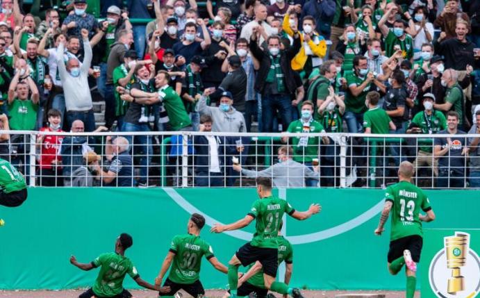 Die Spieler von Preußen Münster jubeln mit ihren Fans. Foto: Guido Kirchner/dpa