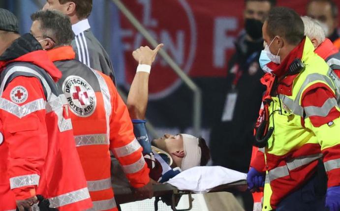 Der Nürnberger Tom Krauß (M) wird verletzt aus dem Stadion getragen, zeigt aber mit dem Daumen nach oben. Foto: Daniel Karmann/dpa