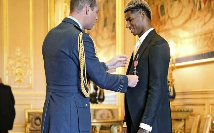 Prinz William (l), Herzog von Cambridge, verleiht Marcus Rashford während einer Zeremonie auf Schloss Windsor einen Orden. Foto: Aaron Chown/PA/AP/dpa