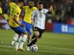 Lionel Messi (r) aus Argentinien in Aktion gegen Matheus Cunha (hinten) und Danilo (l) aus Brasilien. Foto: Gustavo Ortiz/dpa