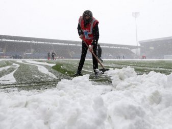 Der Rasen im Staion Turf Moor ist nicht bespielbar: Mitarbeiter räumen den Schnee vom Spielfeld. Foto: Bradley Collyer/PA Wire/dpa Der Rasen im Staion Turf Moor ist nicht bespielbar: Mitarbeiter räumen den Schnee vom Spielfeld. Foto: Bradley Collyer/PA Wire/dpa