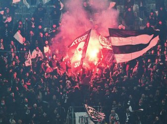 Fans von Besiktas stehen hinter einem Zaun auf der Tribüne und zünden Pyrotechnik. Foto: Bernd Thissen/dpa Fans von Besiktas stehen hinter einem Zaun auf der Tribüne und zünden Pyrotechnik. Foto: Bernd Thissen/dpa