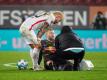 Konrad Laimer von RB Leipzig (M) sitzt verletzt auf dem Spielfeld und wird behandelt. Foto: Matthias Balk/dpa