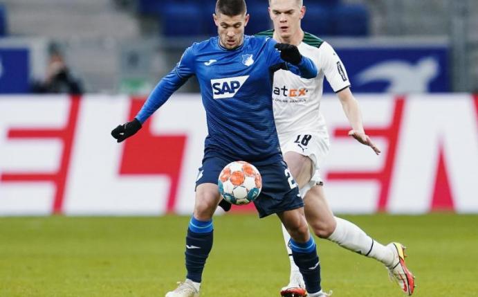 Hoffenheims Andrej Kramaric (l) versucht den Ball vor Gladbachs Matthias Ginter abzuschirmen. Foto: Uwe Anspach/dpa