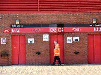 Ein Mitarbeiter geht an der Osttribüne des Old-Trafford-Stadions, der Heimstätte von Manchester United, vorbei. Foto: Anthony Devlin/PA Wire/dpa Ein Mitarbeiter geht an der Osttribüne des Old-Trafford-Stadions, der Heimstätte von Manchester United, vorbei. Foto: Anthony Devlin/PA Wire/dpa