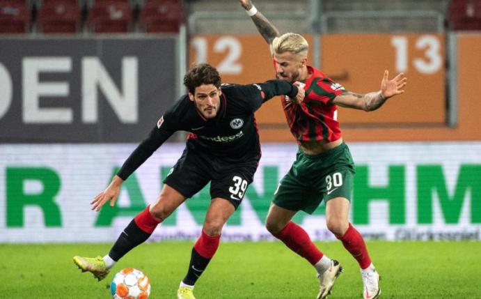 Goncalo Paciencia von Eintracht Frankfurt (l) schirmt den Ball gegen Augsburgs Niklas Dorsch ab. Foto: Matthias Balk/dpa