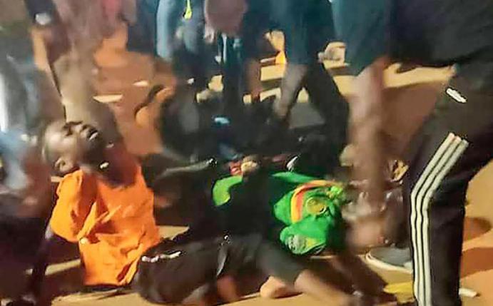 Menschen helfen den Opfern der Massenpanik vor dem Stadion in Yaoundé. Foto: Thierry Noukeu/AP/dpa