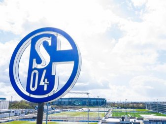 Im Vordergrund dreht sich das Logo des FC Schalke auf der Geschäftsstelle, im Hintergrund steht die Veltins Arena. Foto: Guido Kirchner/dpa Im Vordergrund dreht sich das Logo des FC Schalke auf der Geschäftsstelle, im Hintergrund steht die Veltins Arena. Foto: Guido Kirchner/dpa