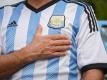 Ein Mann, der ein Trikot der argentinischen Nationalmannschaft trägt, legt sein Hand aufs Herz. (Archivbild). Foto: Julieta Ferrario/dpa