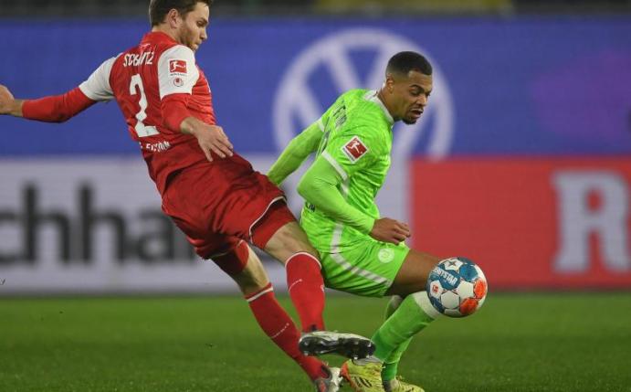 Wolfsburgs Lukas Nmecha (r) behauptet im Zweikampf gegen Kölns Benno Schmitz den Ball. Foto: Swen Pförtner/dpa