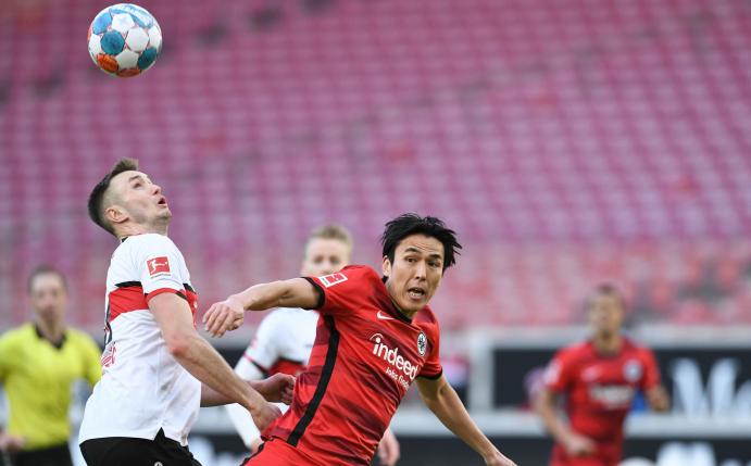 Frankfurts Makoto Hasebe (M) kämpft gegen Stuttgarts Sasa Kalajdzic um den Ball.