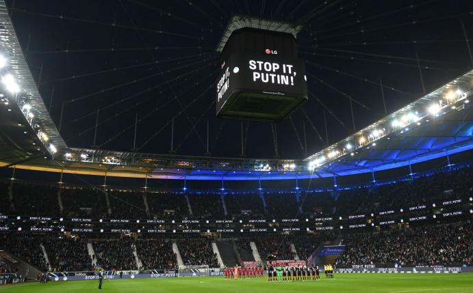 Die Mannschaften von Eintracht Frankfurt und dem FC Bayern München stehen vor dem Spiel während einer Schweigeminute für die Ukraine zusammen.