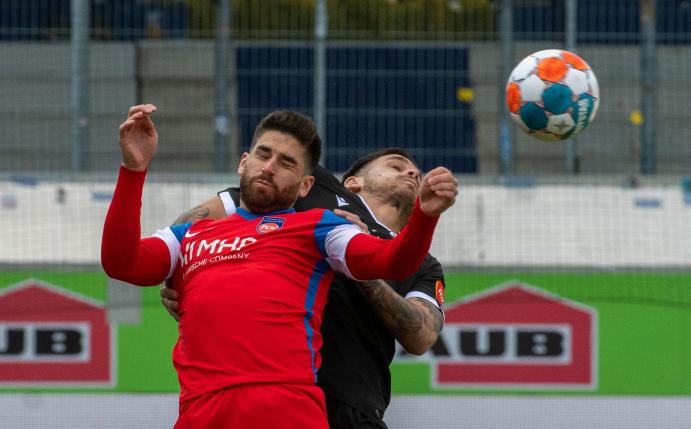 Heidenheims Stefan Schimmer (l) und Dario Dumic vom SC Sandhausen im Kopfballduell.