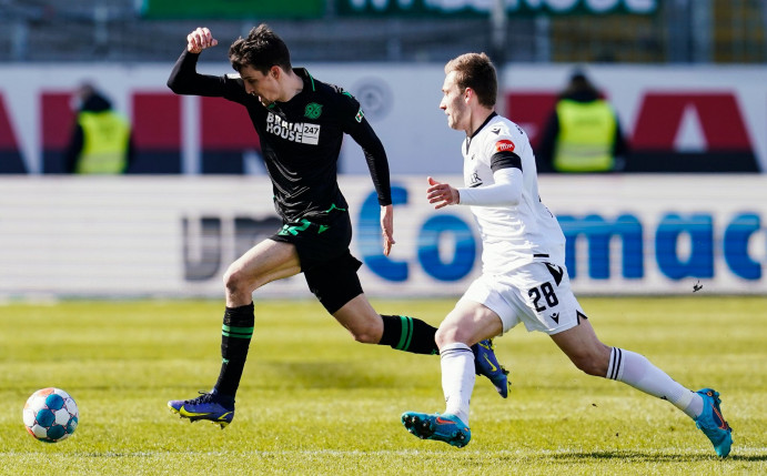 Hannovers Sebastian Stolze (l) und Sandhausens Tom Trybull kämpfen um den Ball.