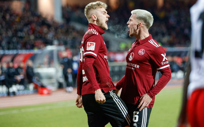 Nürnbergs Tim Handwerker und Lino Tempelmann (r) feiern das späte Siegtor gegen den HSV.