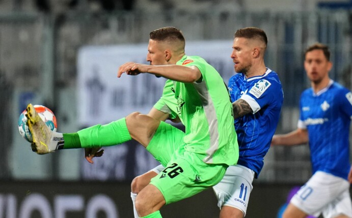 Sandhausens Janik Bachmann (l) kommt vor Darmstadts Tobias Kempe an den Ball.