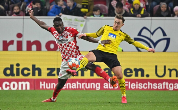 Der Mainzer Moussa Niakhate (l) und Dortmunds Felix Passlack kämpfen um den Ball.