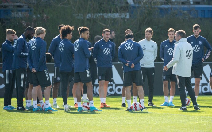 Bundestrainer Hansi Flick (r) wendet sich beim Abschlusstraining an die Spieler der Nationalmannschaft.