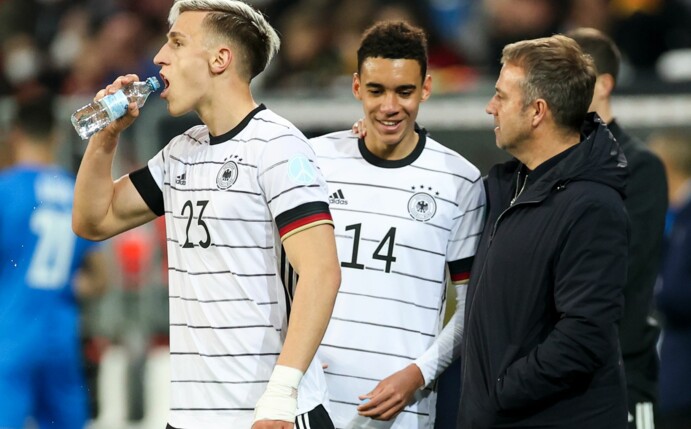 Bundestrainer Hansi Flick (r-l) spricht mit Jamal Musiala, daneben Nico Schlotterbeck.