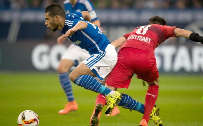 Schalkes Younes Belhanda (l) und Lukas Rupp von Stuttgart kämpfen um den Ball. Foto: Bernd Thissen