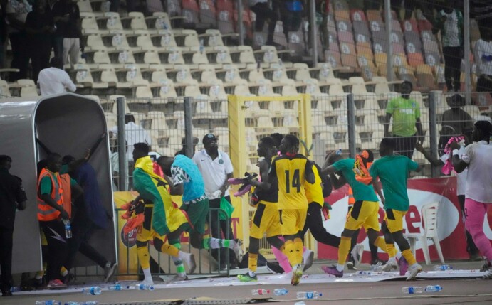 Ghanas Spieler rennen bringen sich nach dem Spiel in Abuja in Sicherheit.