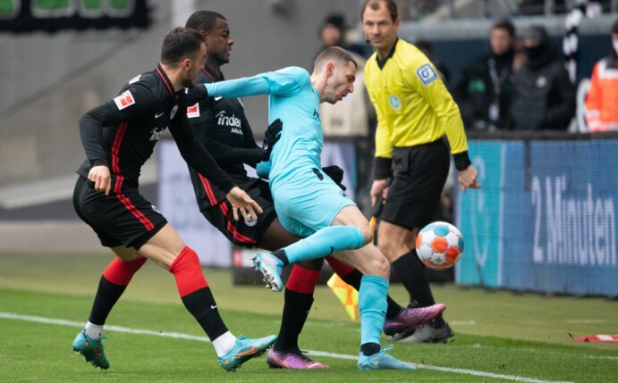 Fürths Branimir Hrgota (r) wird von den Frankfurtern Filip Kostic (l) und Evan Ndicka in die Zange genommen.