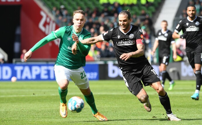 Werder Bremens Niklas Schmidt (l) und Sandhausens Dennis Diekmeier messen sich im Zweikampf.