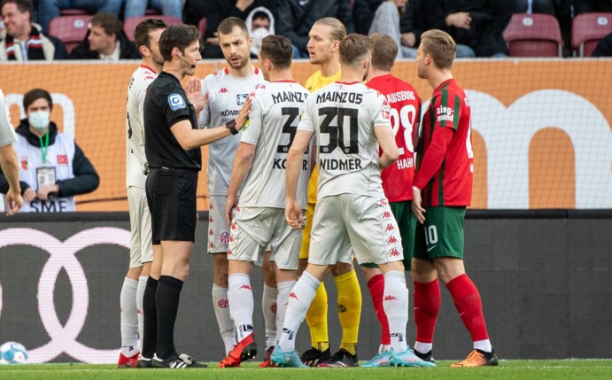Schiedsrichter Matthias Jöllenbeck (l) spricht mit den Spielern.