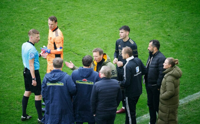 Schiedsrichter Christian Dingert (l) bespricht nach dem Wechselfehler mit Akteuren vom FC Bayern und SC Freiburg das weitere Vorgehen.