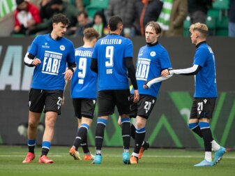 Spieler von Bielefeld tragen beim Aufwärmen ein Trikot mit der Rückennummer 9 und der Aufschrift "Gute Besserung Fabi". Spieler von Bielefeld tragen beim Aufwärmen ein Trikot mit der Rückennummer 9 und der Aufschrift "Gute Besserung Fabi".