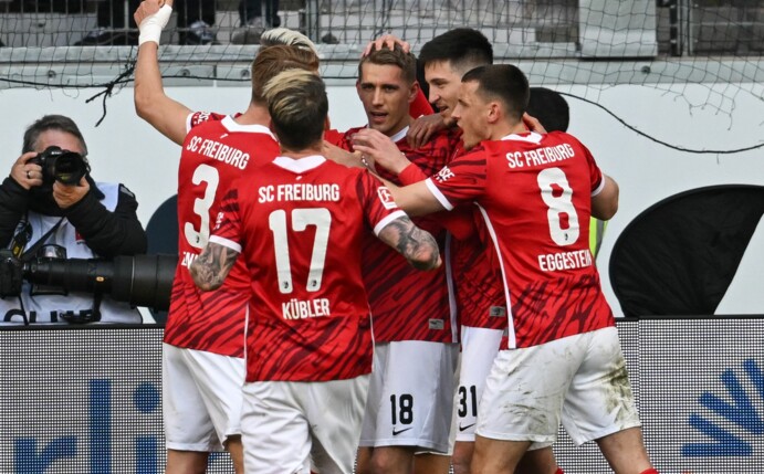 Freiburgs Spieler jubeln nach dem Tor zum 2:1 durch Nils Petersen (M).