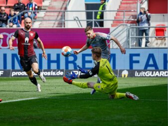 Der Paderborner Florent Muslija (M) in Aktion gegen den Ingolstädter Torwart Robert Jendrusch (r) und Nico Antonitsch. Der Paderborner Florent Muslija (M) in Aktion gegen den Ingolstädter Torwart Robert Jendrusch (r) und Nico Antonitsch.