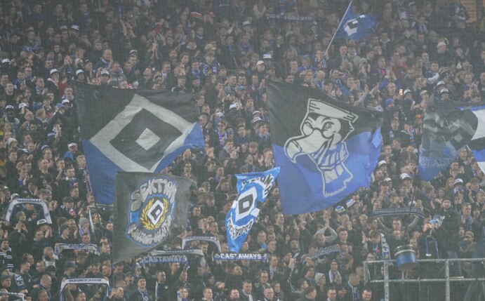 HSV-Fans stehen auf der Tribüne des Volksparkstadions.