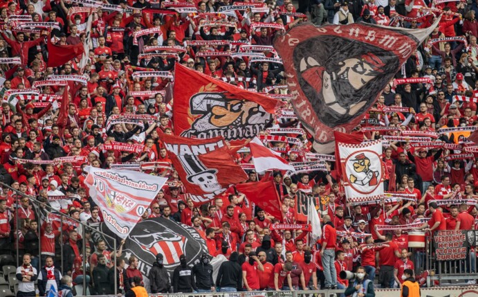 Fans von VfB Stuttgart feuern ihr Team aus dem Gästeblock des Olympiastadions an.