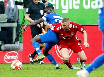 Der Düsseldorfer Jakub Piotrowski (r) hält Braydon Marvin Manu im Zweikampf fest. Der Düsseldorfer Jakub Piotrowski (r) hält Braydon Marvin Manu im Zweikampf fest.