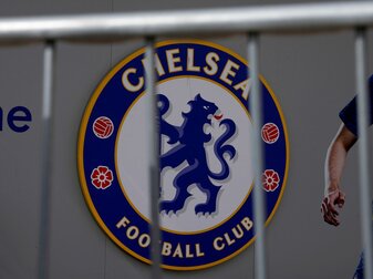 Das Logo des FC Chelsea ist hinter einer Absperrung am Eingang des Londoner Stadions Stamford Bridge zu sehen. Der Verein hat laut Medienberichten neue Besitzer. Das Logo des FC Chelsea ist hinter einer Absperrung am Eingang des Londoner Stadions Stamford Bridge zu sehen. Der Verein hat laut Medienberichten neue Besitzer.