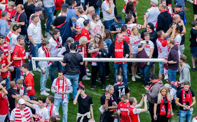 Kölner Fans halten nach einem Platzsturm einen Torpfosten.