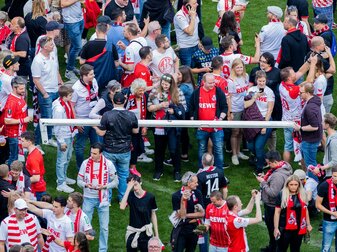 Kölner Fans halten nach einem Platzsturm einen Torpfosten. Kölner Fans halten nach einem Platzsturm einen Torpfosten.
