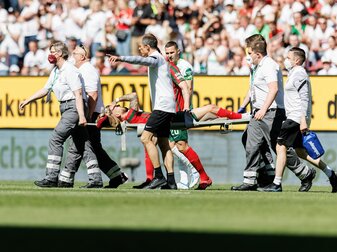 Augsburgs Niklas Dorsch wird verletzt vom Platz getragen. Augsburgs Niklas Dorsch wird verletzt vom Platz getragen.