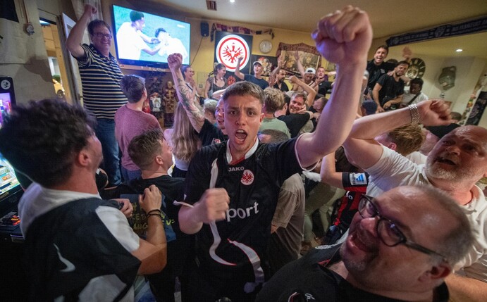Fans von Eintracht Frankfurt feiern den Sieg ihres Teams im Europaleague-Finale in einer Kneipe.
