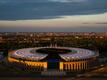 Die untergehende Sonne scheint auf das Olympiastadion in Berlin.